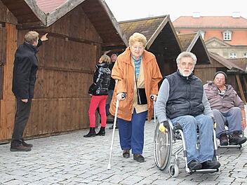 Sie haben es am neuen Standort des Weihnachtsmarktes leichter (von rechts): Viktor Zerr, Luitpold Herrmann und Johanna Strysio. Im Hintergrund sind (von links) Ulf Krause, Michaela Weiss und Dietrich Denzner mit den Aufbauarbeiten für den Weihnachtsmarkt beschäftigt. Foto: C. Igler