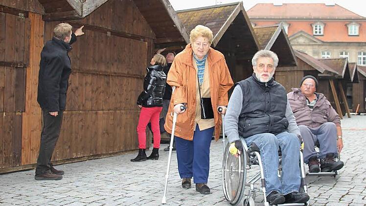 Sie haben es am neuen Standort des Weihnachtsmarktes leichter (von rechts): Viktor Zerr, Luitpold Herrmann und Johanna Strysio. Im Hintergrund sind (von links) Ulf Krause, Michaela Weiss und Dietrich Denzner mit den Aufbauarbeiten für den Weihnachtsmarkt beschäftigt. Foto: C. Igler