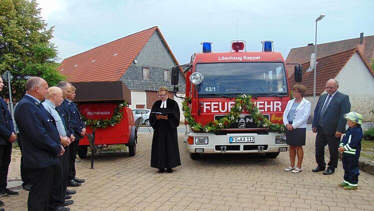 Pfarrer Jacek Kikut segnet das neue Feuerwehrauto und den Zeltanhänger (l.). Foto: Petra Malbrich