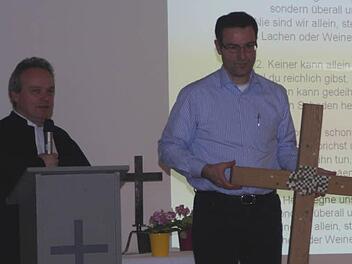 Pfarrer Peter Stier stellt das neue Kreuz vor. Fotos: G. Bauer