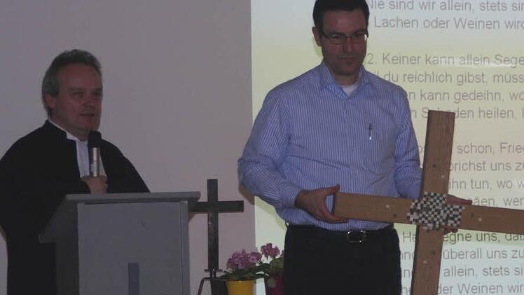 Pfarrer Peter Stier stellt das neue Kreuz vor. Fotos: G. Bauer