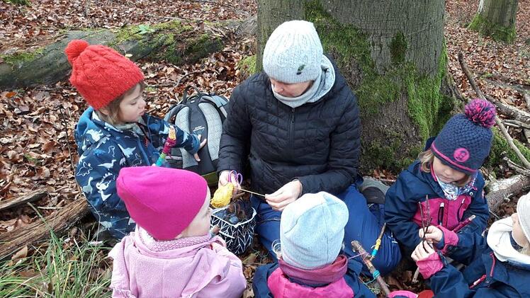 Kinder beim Spielen mit Wollfäden und Ästen. Foto: Andreas Lomb