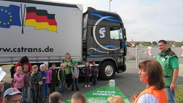 Polizeihauptkommissar Matthias Holzmann erklärt den Kinder den "Toten Winkel" aus der Sicht eines Lkw-Fahrers (vorne re: Kindergartenleiterin Marion Morgenroth, Uetzing)
