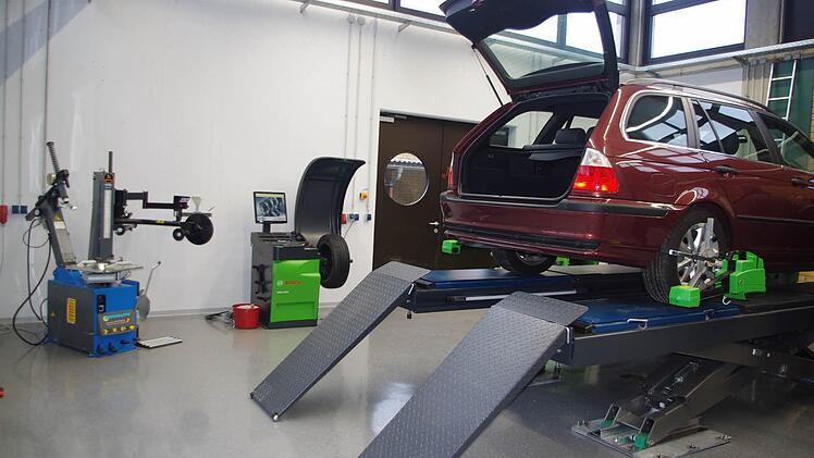 Die neue Kfz-Werkstatt der Berufsschule verfügt über drei Hebebühnen - davon eine mit einem Achsmess-Stand (vorne im Bild) als auch (hinten im Bild) eine Reifenmontiermaschine (links) sowie eine Reifenwuchtmaschine (rechts).
