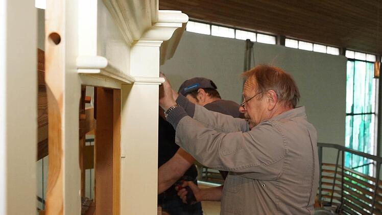 Mitarbeiter schrauben die Holzkonstruktion fest.Foto: Arkadius Guzy