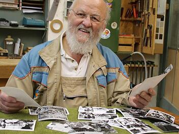 Erinnerungen auf der Werkbank: Schreiner Peter Krug begutachtet die Aufnahmen aus dem Archiv der Saale-Zeitung. Fotos: Ralf Ruppert, Archiv