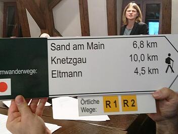 ILE-Managerin Ulla Schmidt (im Hintergrund) erläuterte dem Gemeinderat Oberaurach das Konzept zur Aufwertung der Fünf-Sterne-Gemeinden als Wanderregion. Sie zeigte ein Beispiel für die einheitliche Beschilderung, die mit den Nachbarkreisen abgestimmt ist.Sabine Weinbeer
