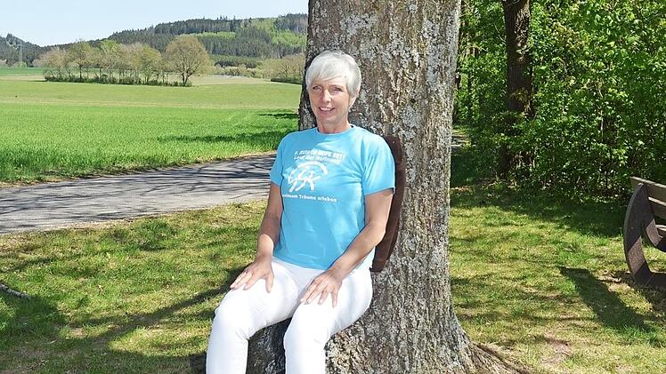 Fitness- und Yogacoach Birgit Schmitt vom Verein "Gemeinsam gegen Krebs" zeigt, wie die Beinmuskeln mit der Sitzhaltung am Baum gestärkt werden.  Foto: Karl- Heinz Hofmann