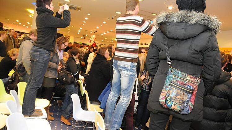 Einige Gäste versuchen über die Menschentraube hinweg, Bilder von Matthäus zu knippsen.