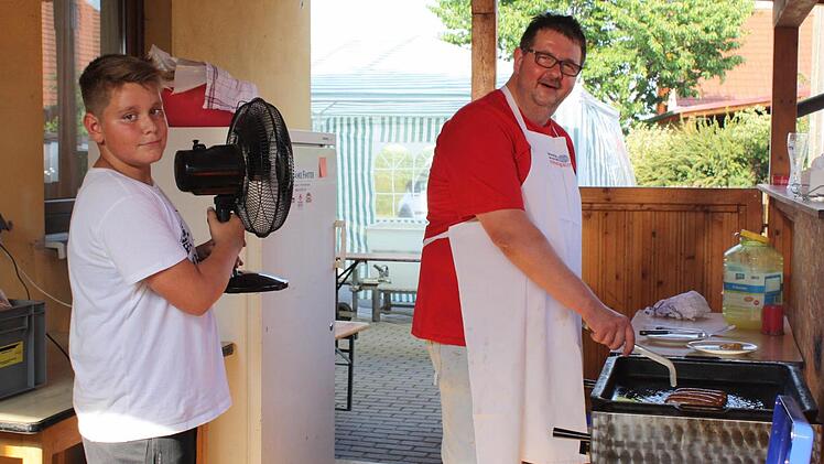 Grillmeister und Feuerwehrkommandant Wolfgang Seitz hatte mit Jungfeuerwehrler Daniel seinen eigenen "Belüfter". Foto: Sonja Werner