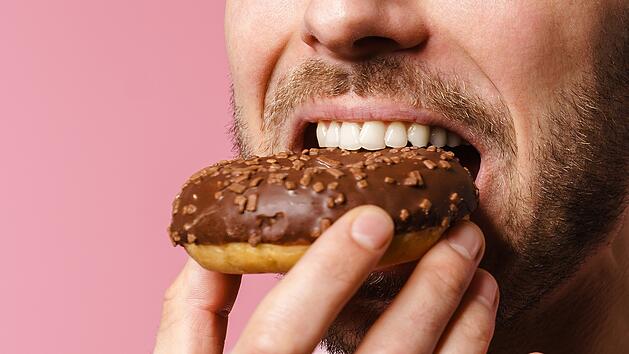 Mann isst Donut