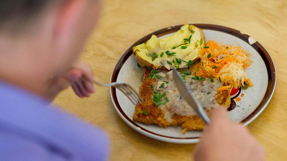 Ein Gast isst ein Mittagsgericht, bestehend aus einem Soja-Schnitzel, Gemüse und einer Ofenkartoffel. Die Grünen wollen nach der Bundestagswahl einen fleischlosen Tag in Kantinen einführen. Foto: Uwe Anspach/dpa