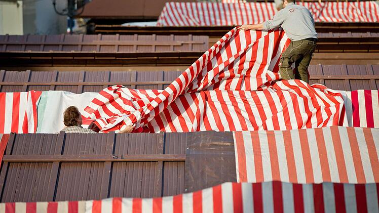 Zwei Männer montieren am 14.11.2014 in Nürnberg (Bayern) die Dachplane an einem Verkaufsstand auf dem Christkindlesmarkt. Am 28. November 2014 wird der Markt offiziell mit dem Prolog des Nürnberger Christkinds eröffnet. Foto: Daniel Karmann/dpa