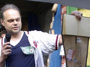 Kurator Roland Halbritter präsentiert das Gästebuch zur Ausstellung. Foto: Winfried Ehling