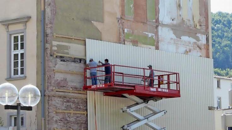Arbeiter verkleideten die Fassade des Neumann-Flügels mit Trapezblech.  Foto: Thomas Mäuser