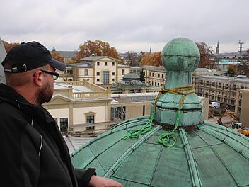 Mit dem Kran setzten Mitarbeiter der Firma Wiedamann die Kugel auf dem Dach des westlichen Eckpavillons wieder auf. Foto: Ralf Ruppert
