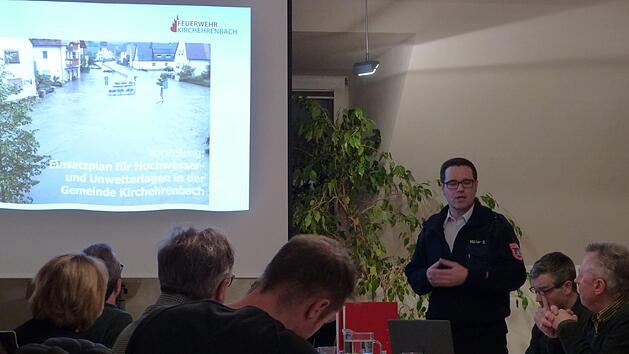 Der Feuerwehrkommandant Sebastian Müller erläutert den Hochwasserplan. Foto: Pauline Lindner