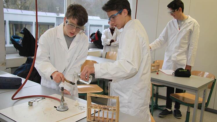 Mirline Kukleci und Luca Schrader dürfen in Chemie selbst Hand anlegen: Beide fügen zu einem Reagenzglas, das Magnesium enthält, Salzsäure dazu, halten dann das Reagenzglas über eine Flamme. Schon knallt's. Foto: Sonja Adam