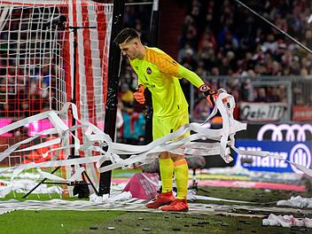 Torwart Fabian Bredlow von N&uuml;rnberg befreit sein Tor von den Papierstreifen, die von Fans zu Beginn der zweiten Halbzeit auf das Spielfeld geworfen wurden. Foto: Matthias Balk/dpa