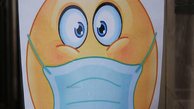 Ein Smiley mit Maske begr&uuml;&szlig;t Besucher vor einem Gesch&auml;ft in der Ha&szlig;furter Innenstadt. Foto: R. Vogt