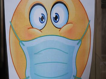 Ein Smiley mit Maske begrüßt Besucher vor einem Geschäft in der Haßfurter Innenstadt. Foto: R. Vogt