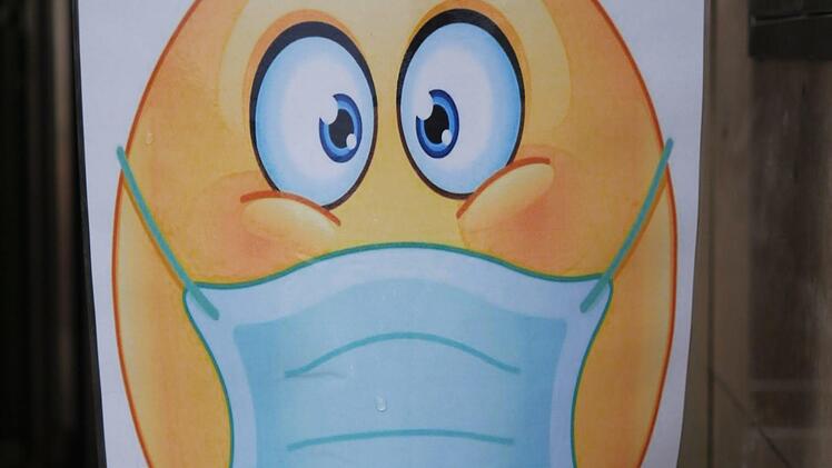 Ein Smiley mit Maske begrüßt Besucher vor einem Geschäft in der Haßfurter Innenstadt. Foto: R. Vogt