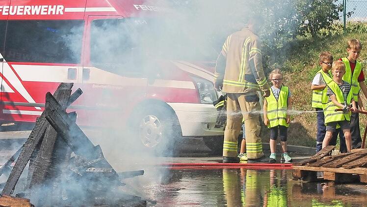 Die kleinen Teilnehmer durften unter Anleitung der Kirchehrenbacher Feuerwehrleute auch selbst ein Feuer löschen. Foto: privat