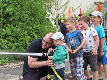 Dieser kleine Feuerwehrmann brauchte noch ein wenig Unterst&uuml;tzung beim Zielspritzen mit der Strahlrohrspritze. Fotos: Alfred Thieret