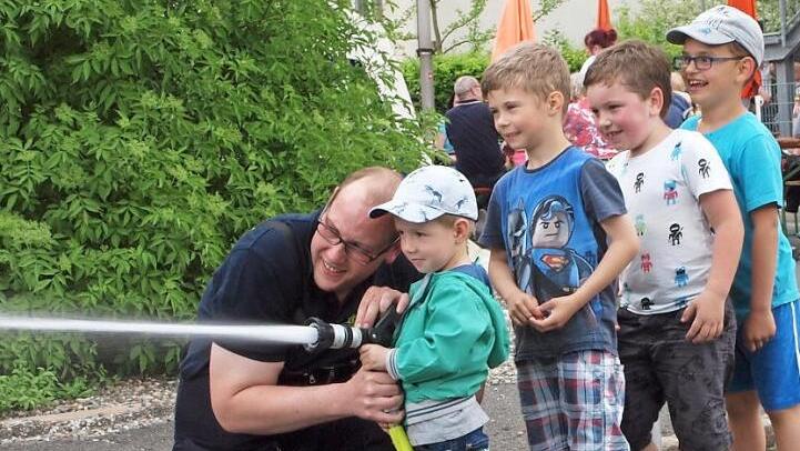 Dieser kleine Feuerwehrmann brauchte noch ein wenig Unterst&uuml;tzung beim Zielspritzen mit der Strahlrohrspritze. Fotos: Alfred Thieret