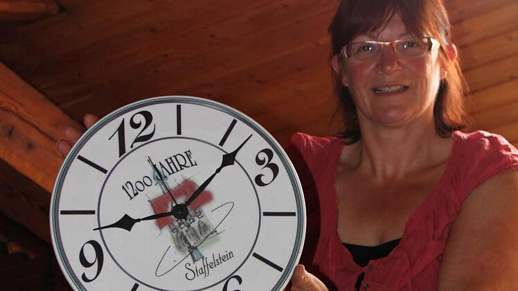 Rosi Jörig mit einer Uhr, die das Emblem 1200 Jahre Staffelstein trägt.