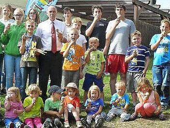 Gemeinsam schleckt es sich am besten. Genüsslich verputzten Kinder, Betreuer und Gäste das von Bürgermeister Franz Uome (hinten siebter von links) spendierte Eis. Mit im Bild die Jugendsprecher Irina Haber (hinten achte von links) und das Team des Spielmobiles (hinten links).  Foto: Klaus-Peter Wulf