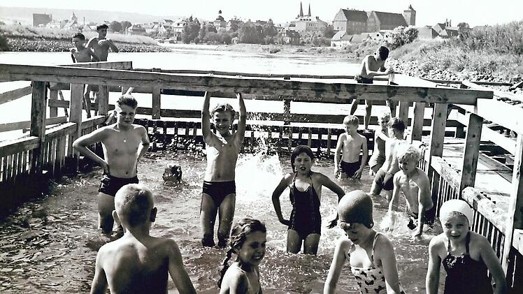 Die Mainbadeanstalt in Ha&szlig;furt in den fr&uuml;hen 1950er Jahren: Noch gab es den Ha&szlig;furter Hafen nicht, in der rechten Bildh&auml;lfte gut zu erkennen sind der Obere Turm und das heutige Landratsamt, damals als "Herrenhof" die Beherbergungsst&auml;tte f&uuml;r die h&ouml;here Bildungsanstalt, Vorl&auml;ufer des Regiomontanus-Gymnasiums.