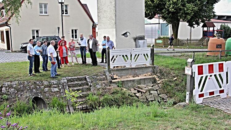 Vor der abgebrochenen Fußgängerbrücke über den Eichelbach stand der Bauausschuss mit Bürgermeister Jürgen Hennemann (3. von rechts). Nach Beschluss des Gremiums wird eine neue Brücke durch den Bauhof der Stadt Ebern errichtet. Foto: Helmut Will