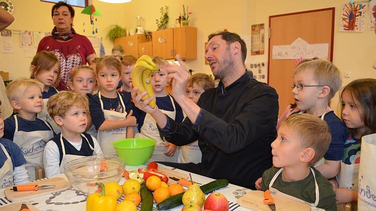 TV-Koch Mirko Reeh erklärt den Kindern, wie Obst und Gemüse zerkleinert werden. Foto: Gabi Bertram