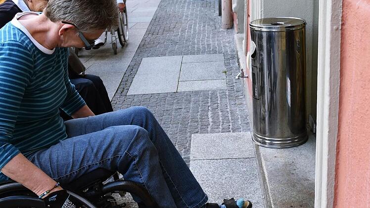 In vielen historischen Häusern in der Innenstadt stellen zwei Stufen unüberwindbare Hürden für Rollstuhlfahrer dar, demonstriert Elvira Stoll. Foto: Gabi Arnold