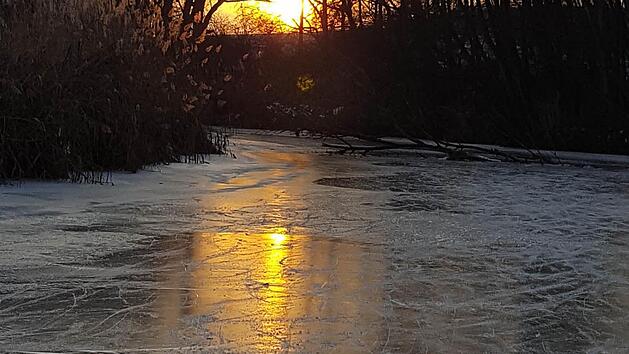 Das eisige Wetter hat auch sch&ouml;ne Seiten: Sonnenuntergang beim Schlittschuhlaufen auf der Aisch bei Trailsdorf Foto: G&uuml;nter Scheller