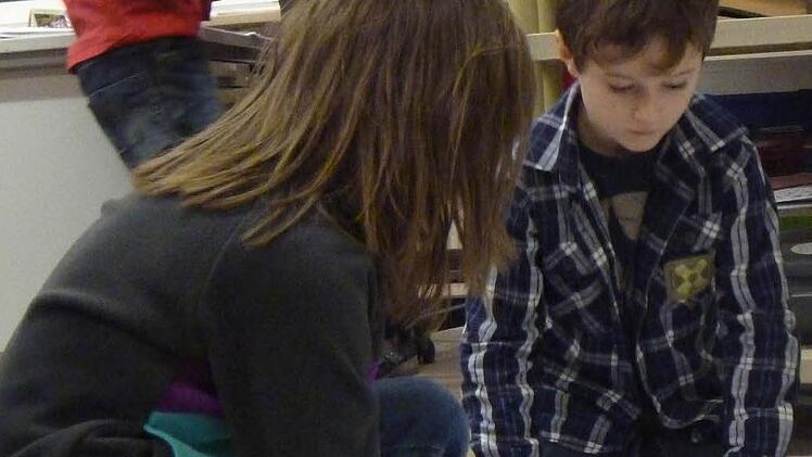 Eigenständiges Arbeiten: Zwei Erstklässler holen sich ihre Arbeitsblätter. Wer Fragen hat, kann sich an die Lehrerin wenden.
