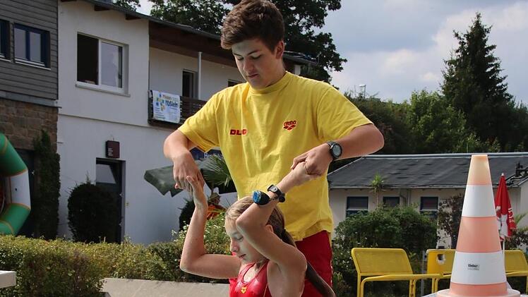 Lisa Wagner (im Wasser) und Jannis Trinkwalter wissen, welche Handgriffe nötig sind, um die Schwimmerin Denis Will aus dem Wasser zu ziehen.Matthias Einwag