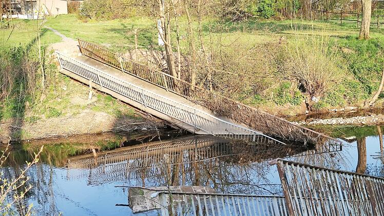 Die irreparablen Brückenteile der im März eingestürzten und zerstörten Fußgängerbrücke über die Haßlach bei Gundelsdorf. Der Abtransport und die Entsorgung gestalten sich schwierig.  Foto: Karl-Heinz Hofmann