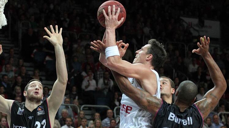 Brose-Kapitän Casey Jacobsen wird beim Wurf von Ronny Burrell (r.) gefoult; links der Bayreuther Philipp Heyden. Fotos: sportpress