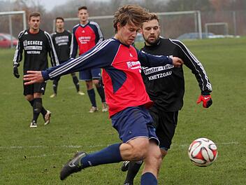 Der Knetzgauer Spielertrainer Matthias Strätz (links) steht im eigenen Strafraum richtig und klärt mit einemBefreiungsschlag gegen den Krumer Stürmer Felix Hart. Foto: Günther Geiling