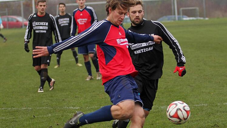 Der Knetzgauer Spielertrainer Matthias Strätz (links) steht im eigenen Strafraum richtig und klärt mit einemBefreiungsschlag gegen den Krumer Stürmer Felix Hart. Foto: Günther Geiling