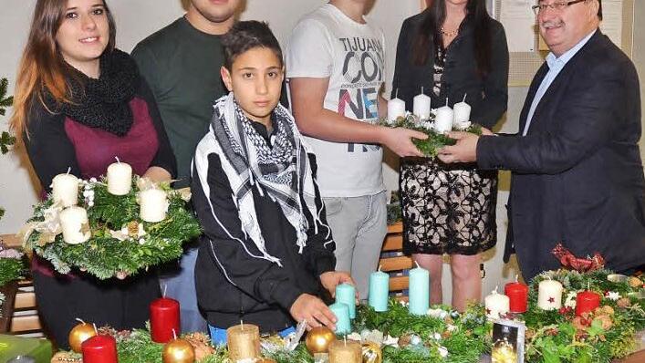 Beim Adventskranzverkauf (von links) Lea Ettlich, Samed Alkoyun, Rodi Güzel, Felix Beez, Vertrauenslehrerin Alexandra Toll und Schulleiter Reinhard Horn  Foto: Karl-Heinz Hofmann