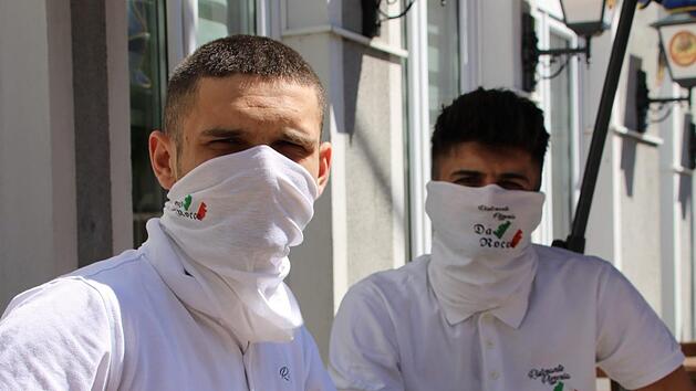 F&uuml;r viele Gesch&auml;ftsleute und Gastronome wird die Maske zum st&auml;ndigen Begleiter. Auf dem Bild tragen Veselj (links) und Alban Mahmudi vom Restaurant Da Rocco den Mund- und Nasenschutz. Foto: Ulrike M&uuml;ller