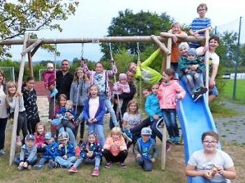Auf dem Spielplatz der Schulsportanlage stellen sich alle der Kamera zu einem gemeinsamen Foto.  Foto: Klaus-Peter Wulf