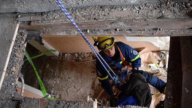 Durch die Decke: Maximilian Schubert bereitet einen ‚Verletzten‘ zum Transport ins darüber liegende Stockwerk vor. Foto: THW/Daniel Schell