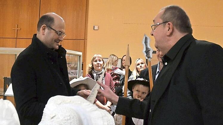 Henning Schuster (rechts) überreicht Bayerns Minister Albert Füracker die Bewerbung um eine Aufnahme des Meederer Friedensfestes in die Liste des immateriellen Weltkulturerbes. Foto: Rainer Lutz