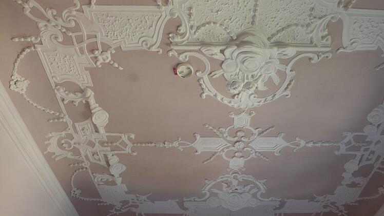 Der Einbau von Brandmeldern kann in einem Prunkbau des 17. Jahrhunderts nicht immer so einfach wie bei einem modernen Gebäude erfolgen. Die Halterungen und Melder sind wie hier an der Decke in einem Prunkraum im dritten Obergeschoss des Langheimer Amtshofs mit viel Rücksicht auf die spätbarocken Stuckarbeiten eingebaut worden und fallen neben den Engelsköpfen kaum auf. Holger Peilnsteiner