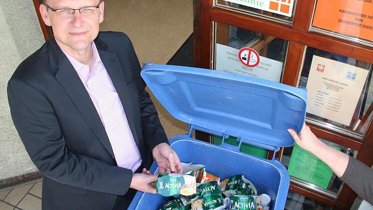Caritas-Geschäftsführer Peter Ehmann vor einer Tonne mit ausgelaufenen Lebensmitteln des Sozialladens, die teuer entsorgt werden müssen. Auflagen verhindern die kostenlose Abgabe als Tierfutter. Foto. A. Oswald