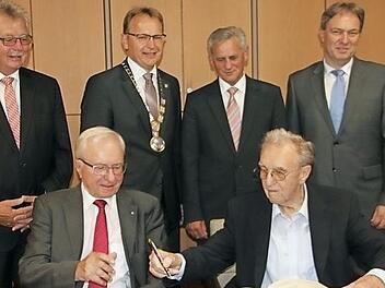 Heinz Köhler und Raimund Schramm tragen sich in das Goldene Buch der Gemeinde Küps ein.  Foto: Veronika Schadeck